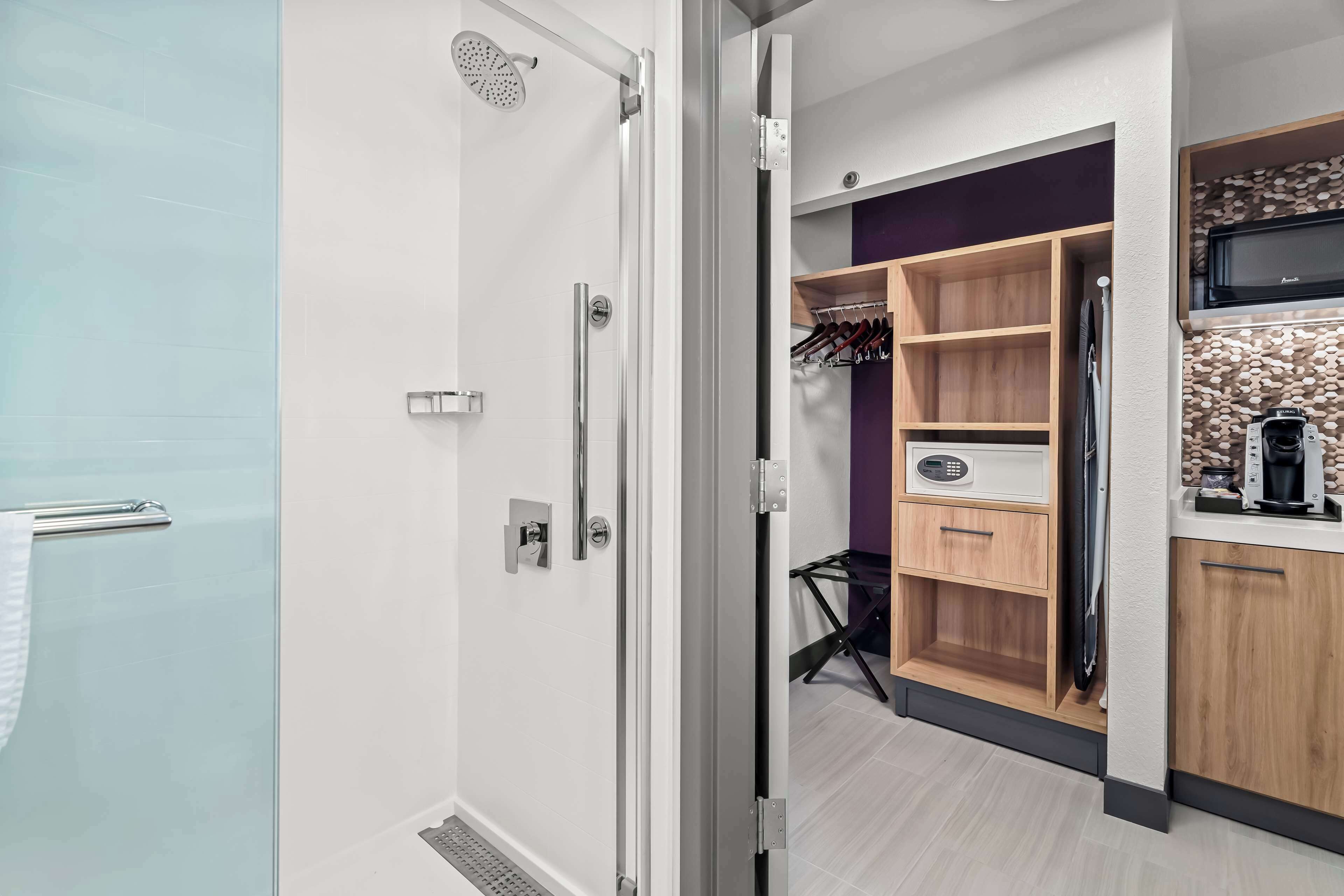 A modern bathroom with a glass shower enclosure, a white toilet, and a towel rack.