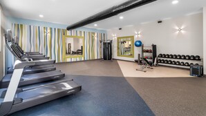 A gym with treadmills, weight machines, and a mirror. - Hilton Garden Inn Cartersville (Cartersville)