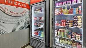 Twee gekoelde vitrines in een winkel, waarvan één 'TREATS' en de andere 'koud' staat.
