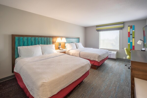 A hotel room with two beds, a desk, a chair, a window, and a radiator. - Hampton Inn Elkhorn Lake Geneva Area (Elkhorn)