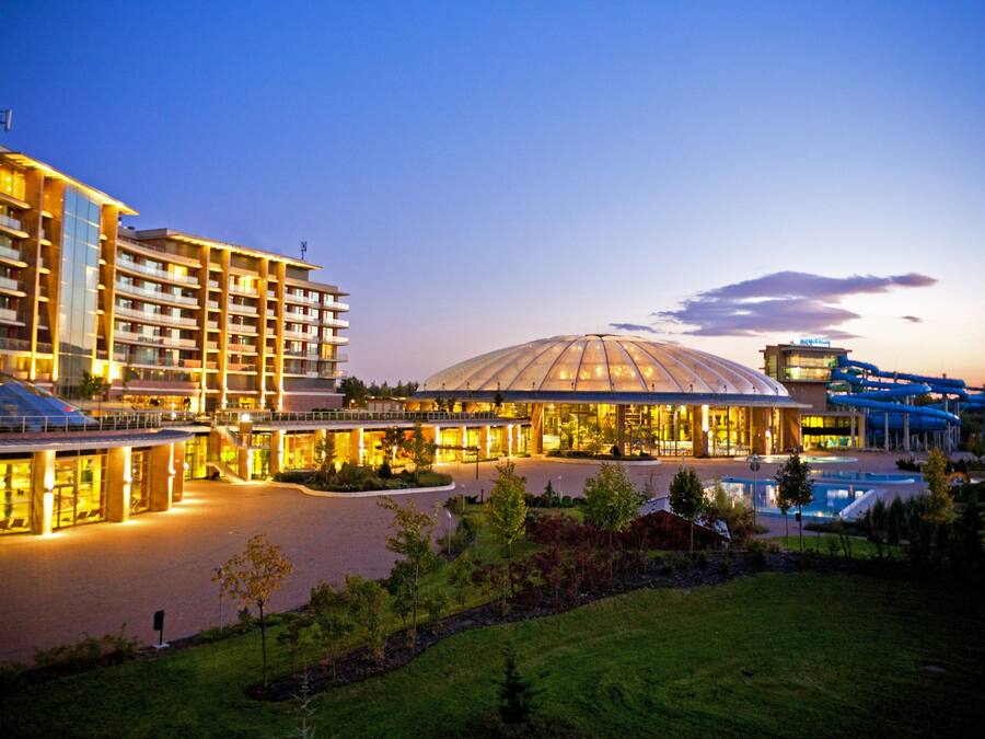 A hotel with multiple buildings, a large dome structure, and water slides.