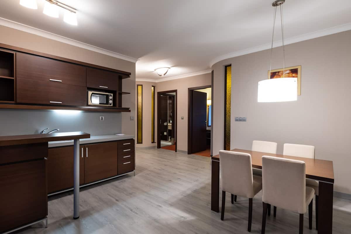 A modern kitchen with a microwave, cabinets, and a dining area with a table and chairs.