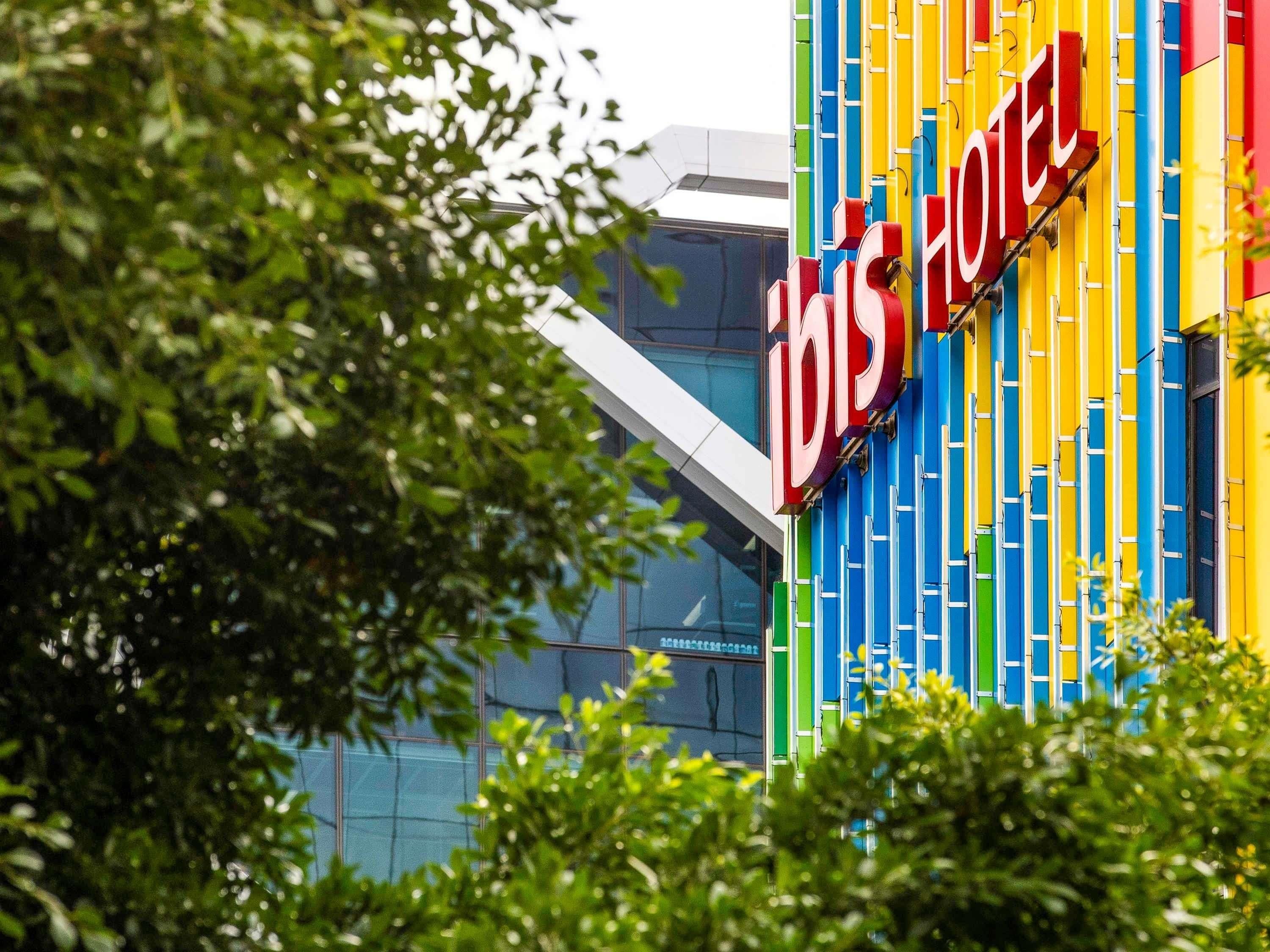 A hotel sign with vertical stripes in blue, yellow, and red.