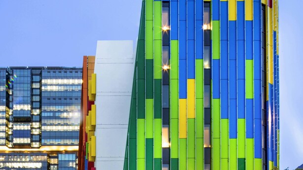 Un moderno edificio de hotel con fachada colorida y el nombre 'ibis HOTEL' bien visible.