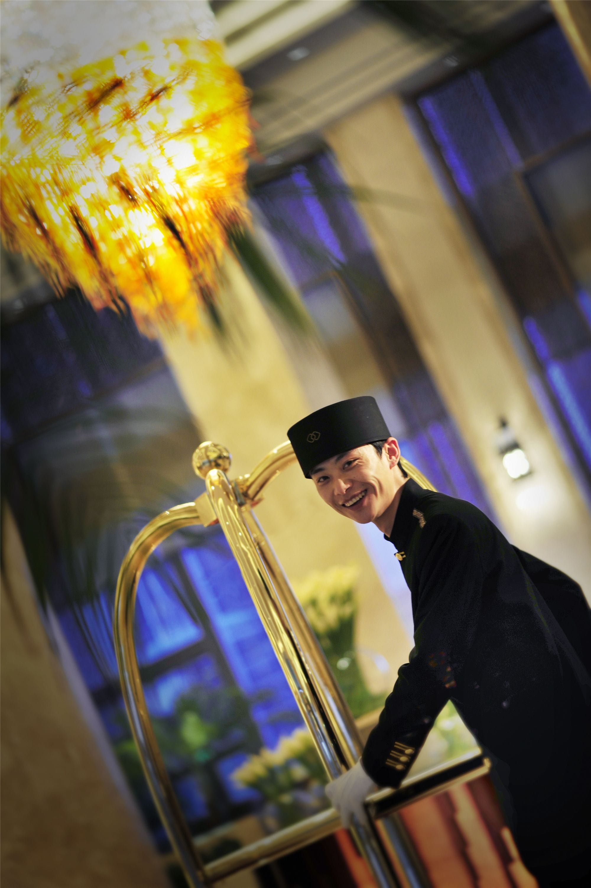 A person in a black uniform standing next to a golden structure with a reflective surface.