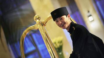 A person in a black uniform standing next to a golden structure with a reflective surface.