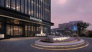 A Sheraton hotel with a fountain in the courtyard.