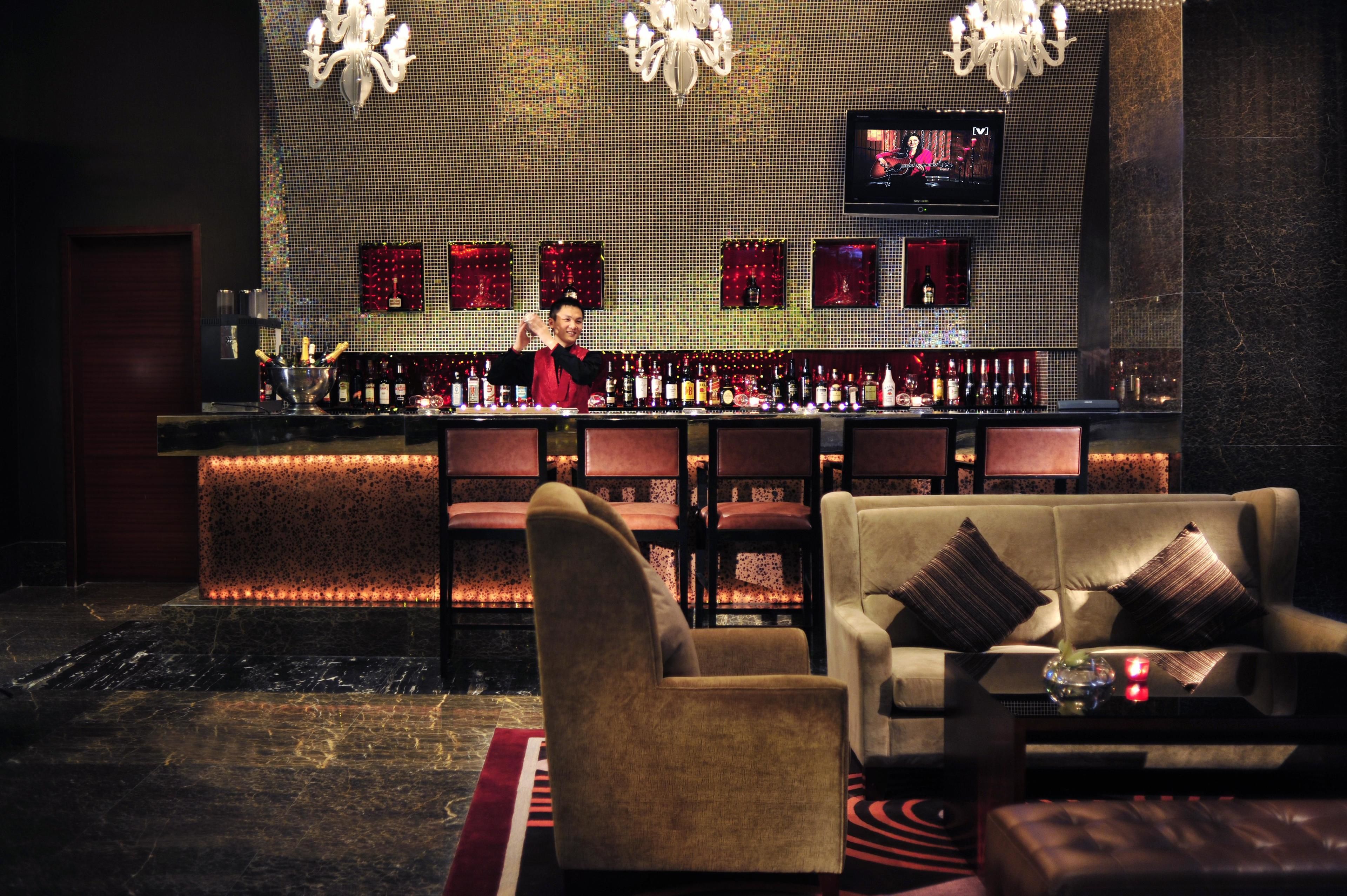 A bar area with a bartender, bar counter, and seating.