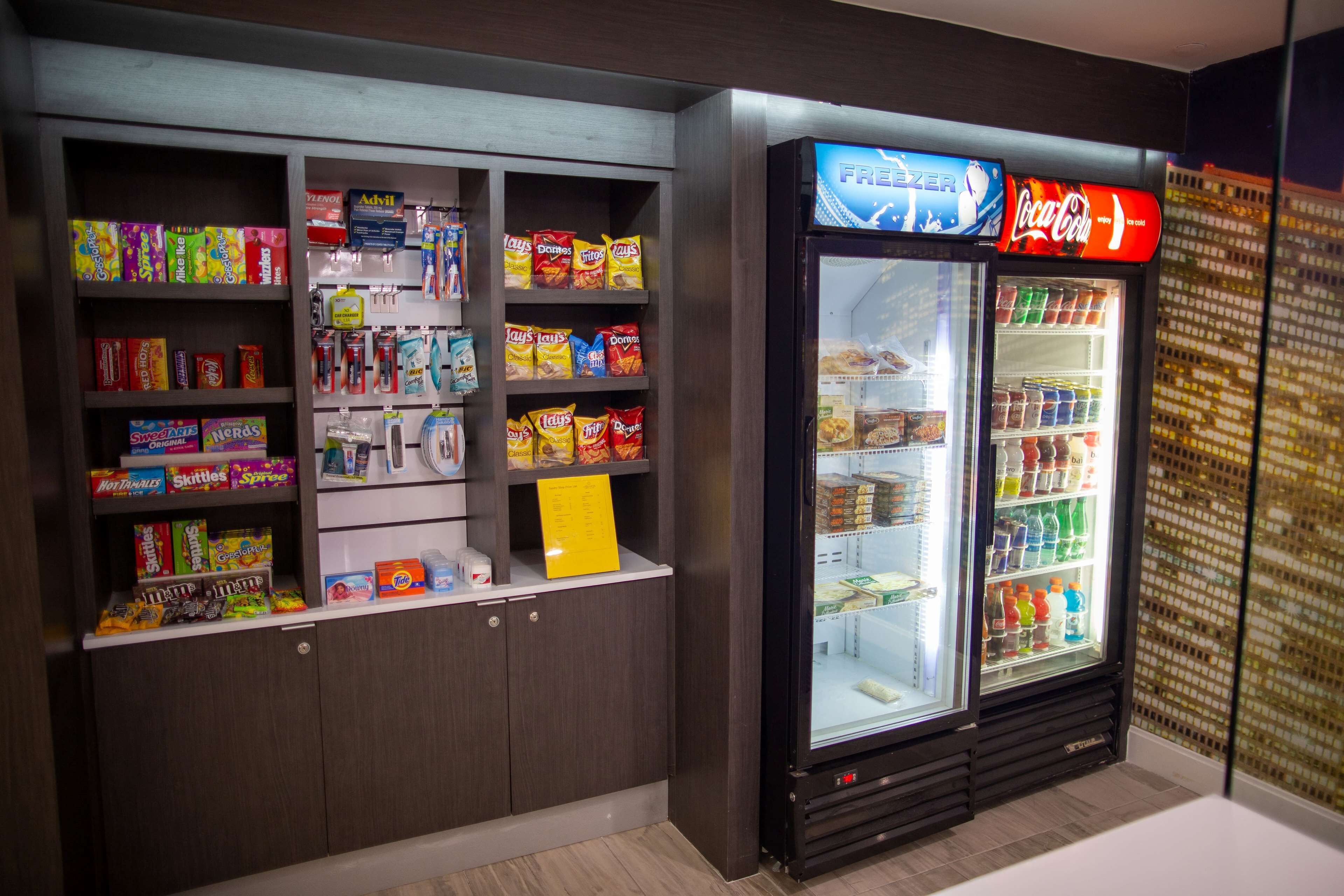 A vending machine with snacks and a Coca-Cola refrigerator in a store.