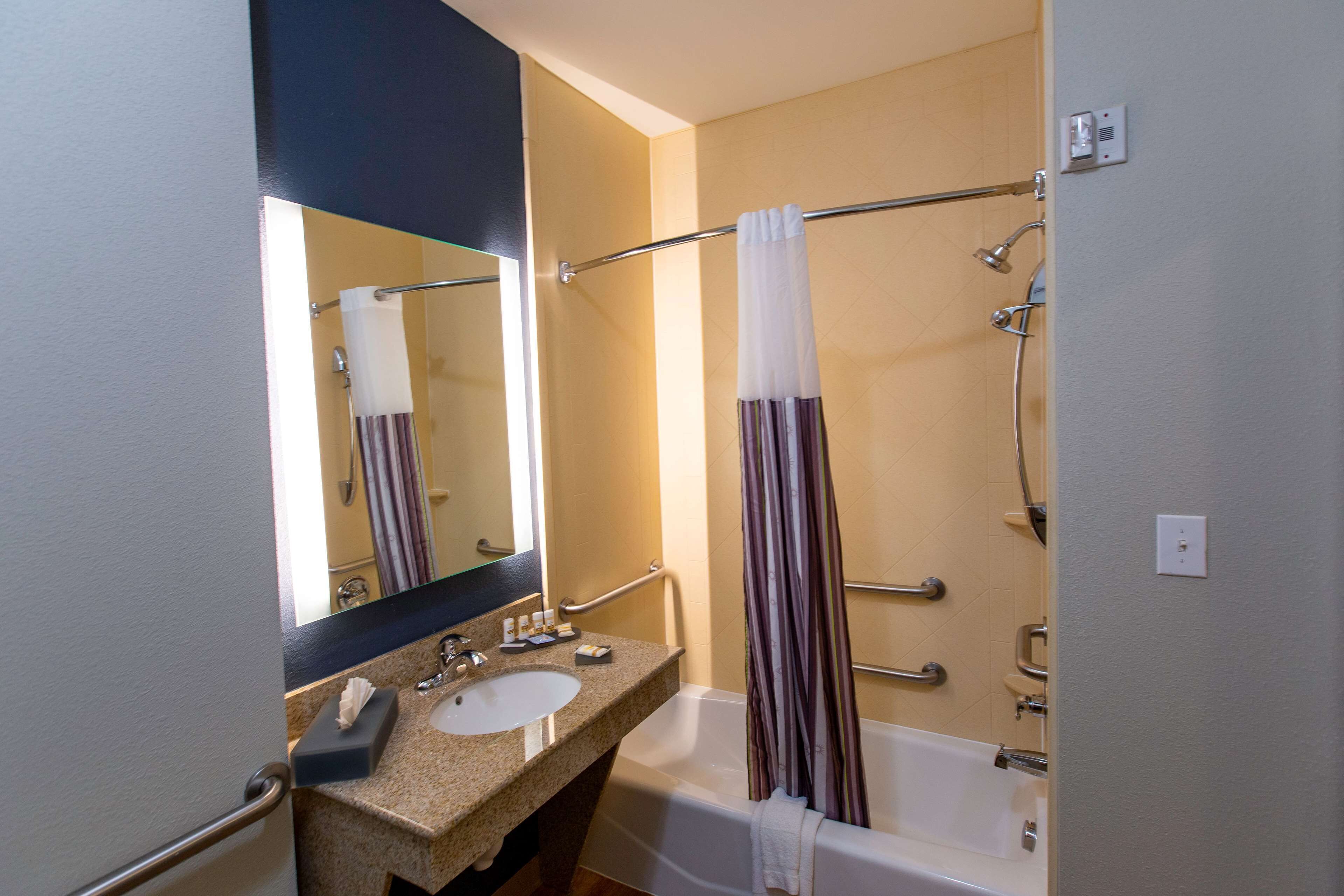 Un baño con lavamanos, espejo y bañera.