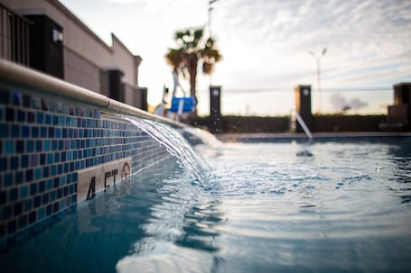 Una piscina al aire libre, sillones reclinables de piscina