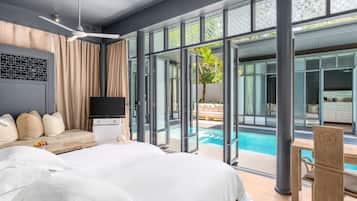 Habitación de hotel moderna con una cama grande, un televisor de pantalla plana, una zona de estar con sofá y cojines, y vistas a una piscina exterior.