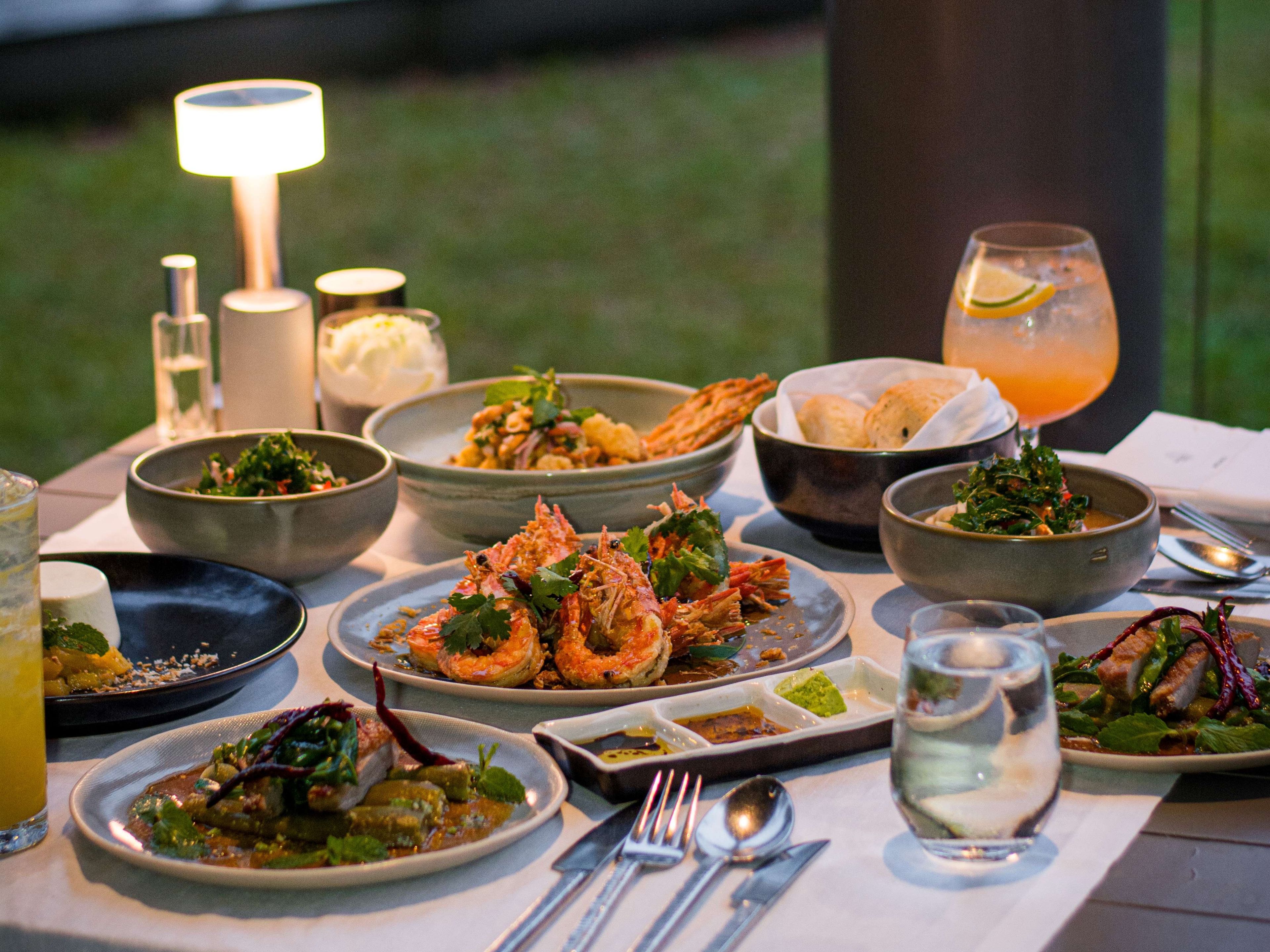 A table set for a meal with various dishes, glasses, and cutlery.