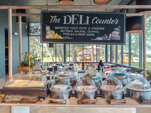 Un comptoir de charcuterie où sont affichées les différentes options proposées, comme les charcuteries, les fromages et les salades artisanales.