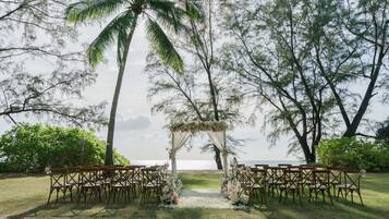 Decoración de boda al aire libre con un arco floral y sillas dispuestas para los invitados.
