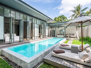 Een zwembad in moderne stijl met helder water, ligbedden en een spa-ruimte met glazen wanden.