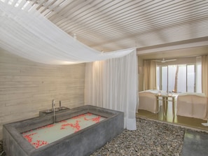 Een moderne badkamer met een vrijstaand bad, een houten wand en een glazen douchecabine.