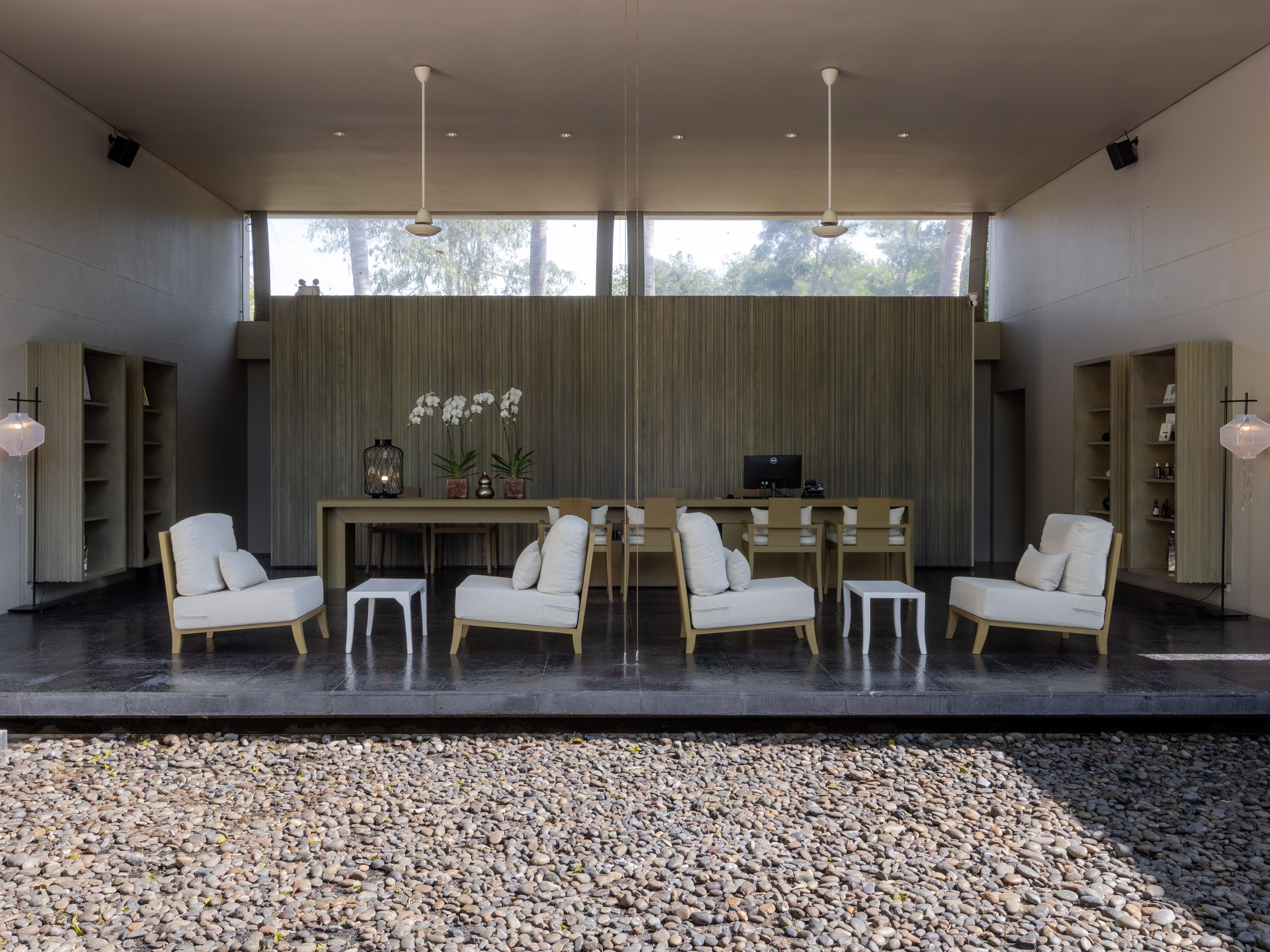 A modern interior with a seating area, a desk, and a large window.