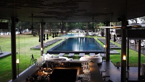 A poolside bar area with lounge chairs and a view of an outdoor pool. - SALA Phuket Mai Khao Beach Resort (Mai Khao)