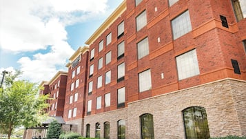 Um edifício de tijolos vermelhos com várias janelas e uma placa que diz "Staybridge Suites".