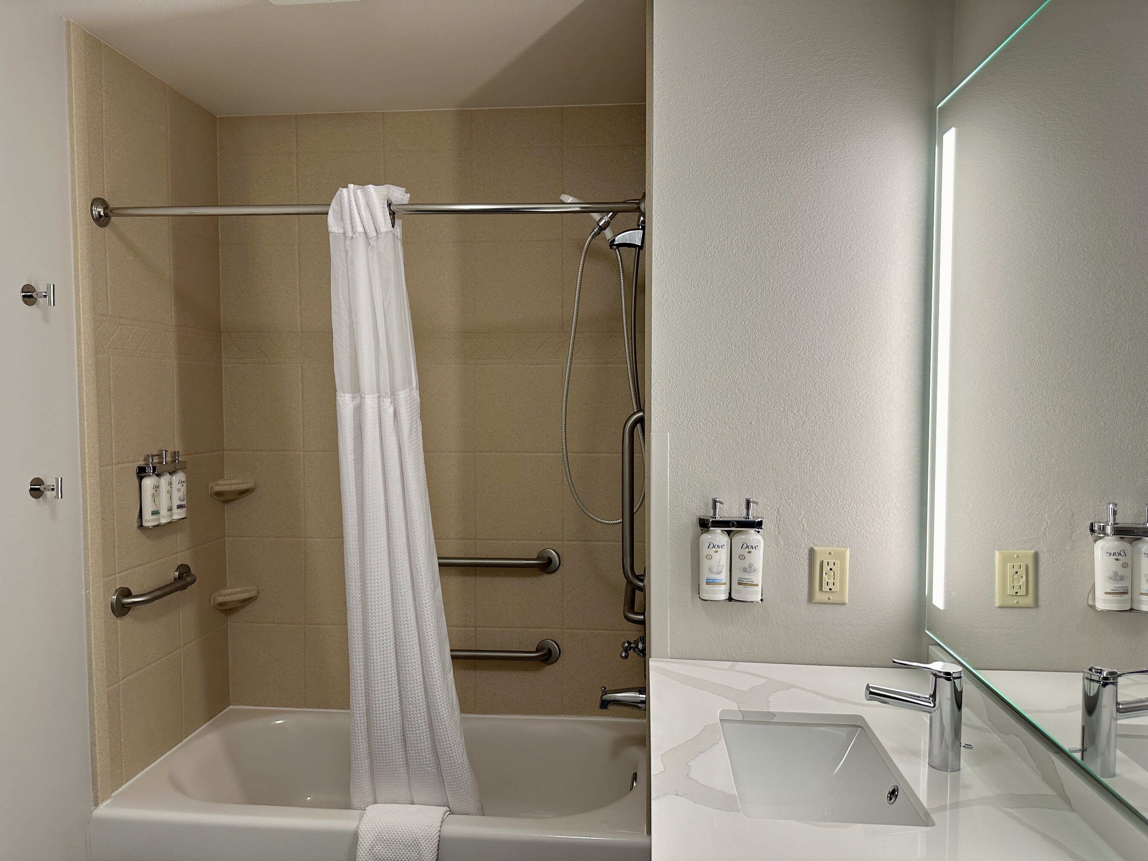 Une salle de bain moderne avec une baignoire, une douche et un lavabo entouré de parois en verre.