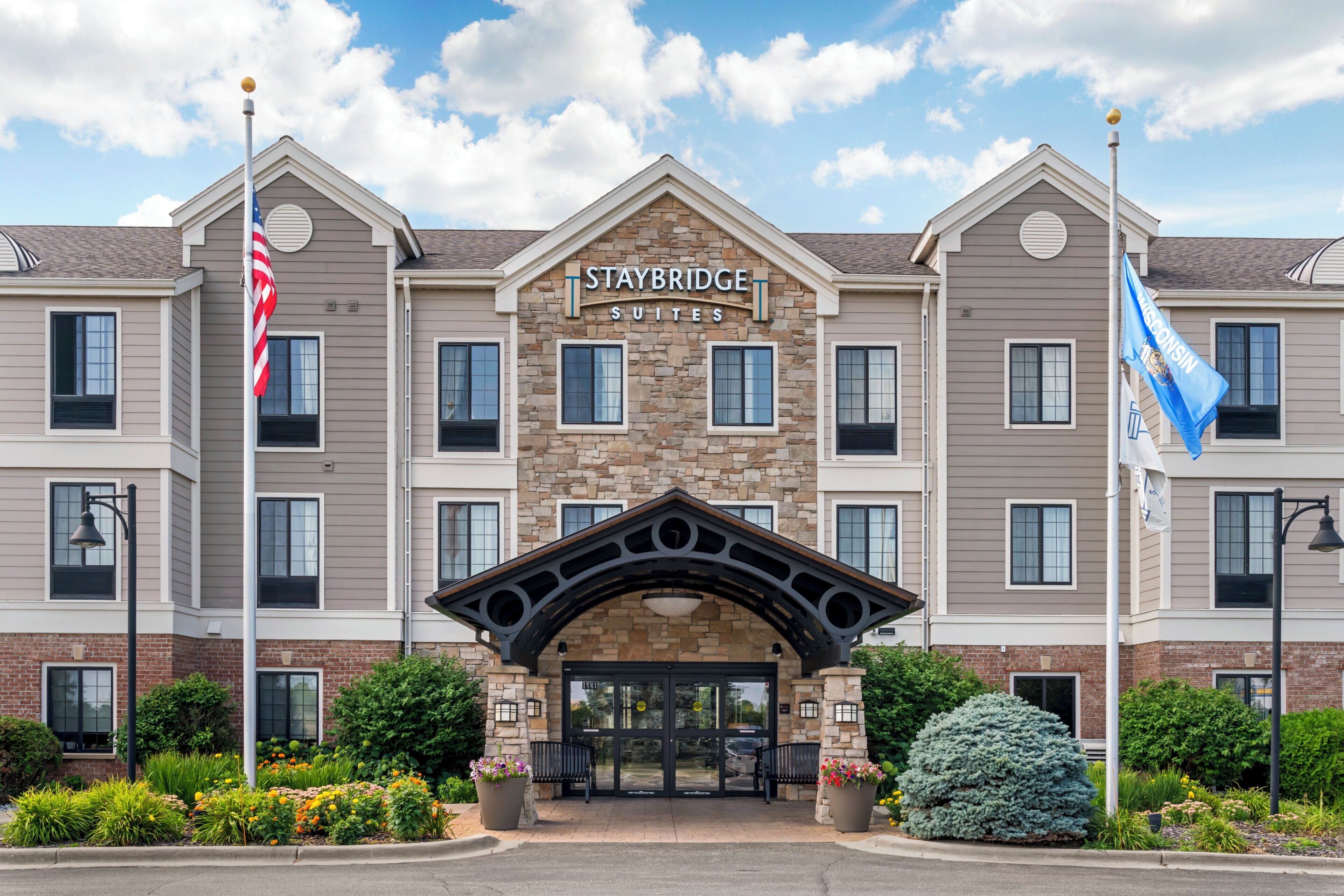 A Staybridge Suites hotel with a stone facade, multiple windows, and a central entrance.