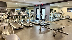 A gym with treadmills, elliptical machines, and weight benches.