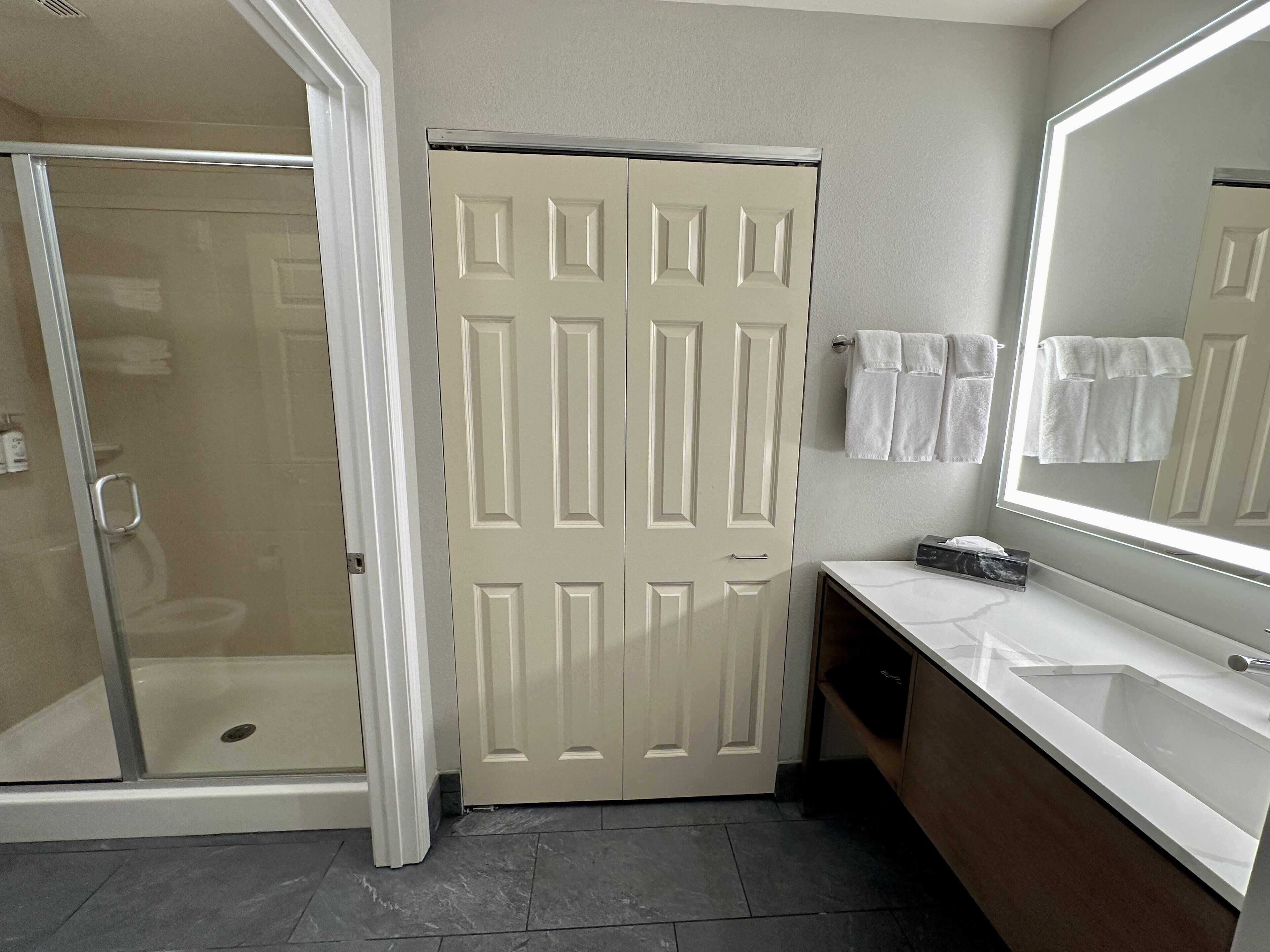 A bathroom with a shower, toilet, and sink.