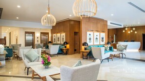 A modern lobby with seating areas, a reception desk, and artwork on the walls. - Staybridge Suites Cairo Citystars by IHG (Cairo)