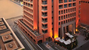A high-rise hotel with multiple floors, balconies, and a rooftop area with outdoor seating. - Staybridge Suites Cairo Citystars by IHG (Cairo)