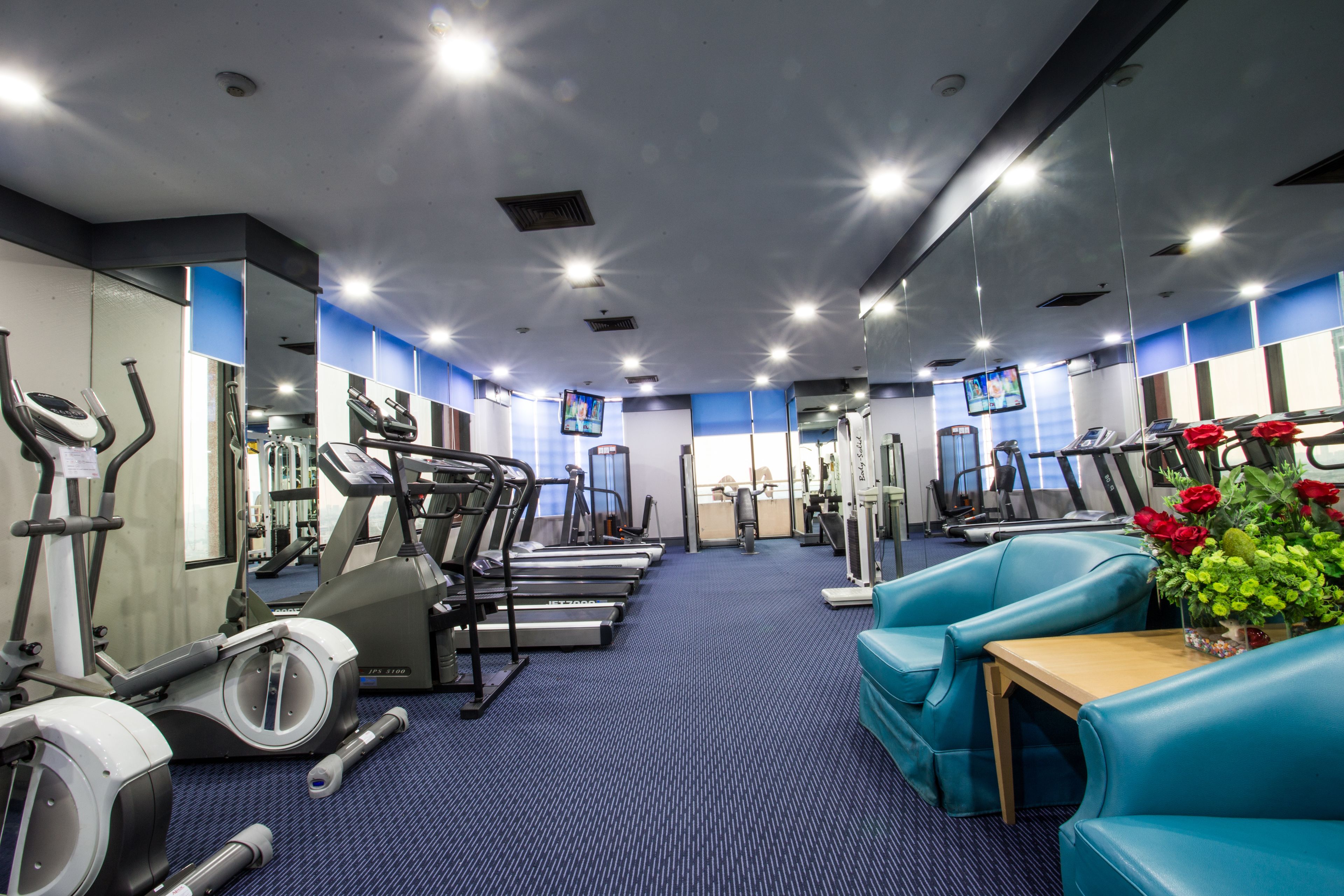 Ein Fitnessstudio mit Laufbändern, Crosstrainern und Krafttrainingsgeräten.