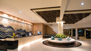 A modern lobby with a reception desk, seating area, and a decorative ceiling. - The Cha-am Methavalai Hotel (Cha-am)