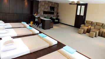 Relax in a serene space with a long bed, desk, and comfortable seating area.