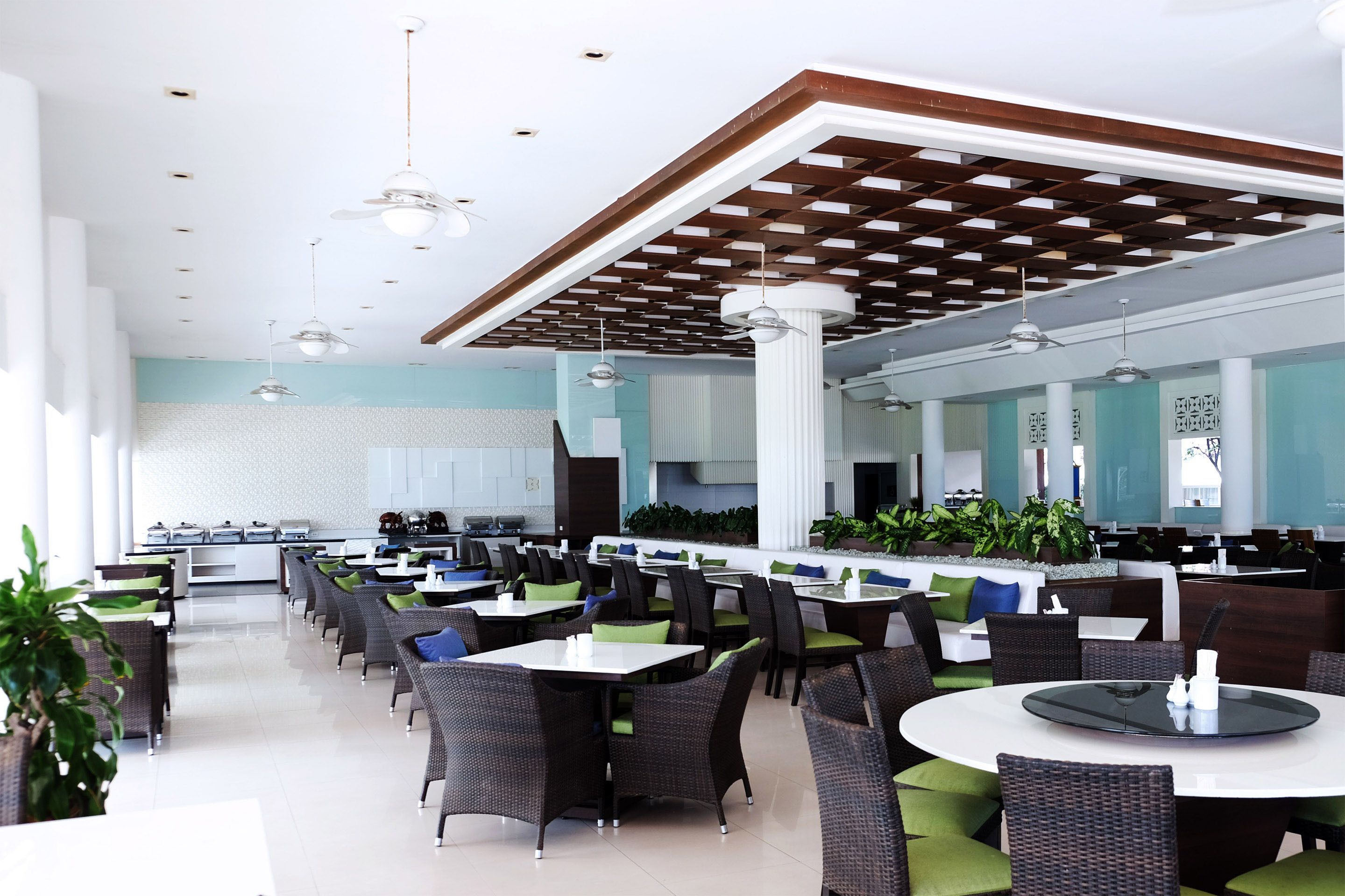 A spacious restaurant with high ceilings, modern lighting, and a mix of seating arrangements including tables and booths.