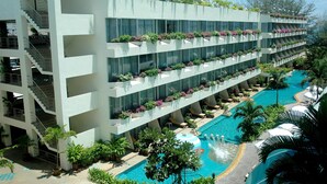 A multi-story hotel with a swimming pool, balconies with plants, and a staircase. - The Cha-am Methavalai Hotel (Cha-am)