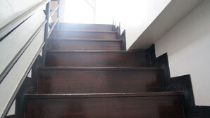 A wooden staircase with metal railings leading to a higher floor. - Lamai Apartment (Patong)