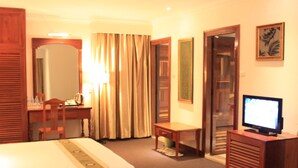 A hotel room with a bed, a desk, a television, and a mirror. - Diamond Hotel (Phnom Penh)