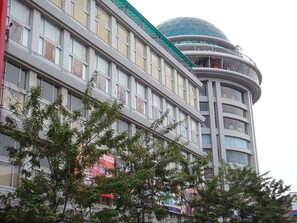 A multi-story hotel with a distinctive curved tower and a dome-like structure on top. - Diamond Hotel (Phnom Penh)