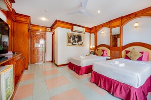 A hotel room with two beds, a wooden wardrobe, a desk, and a ceiling fan. - Lamai Hotel (Patong)