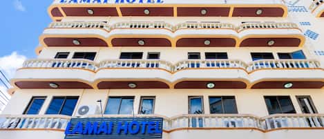 Un hotel de varios pisos con balcones y un letrero que dice "LAMAI HOTEL".