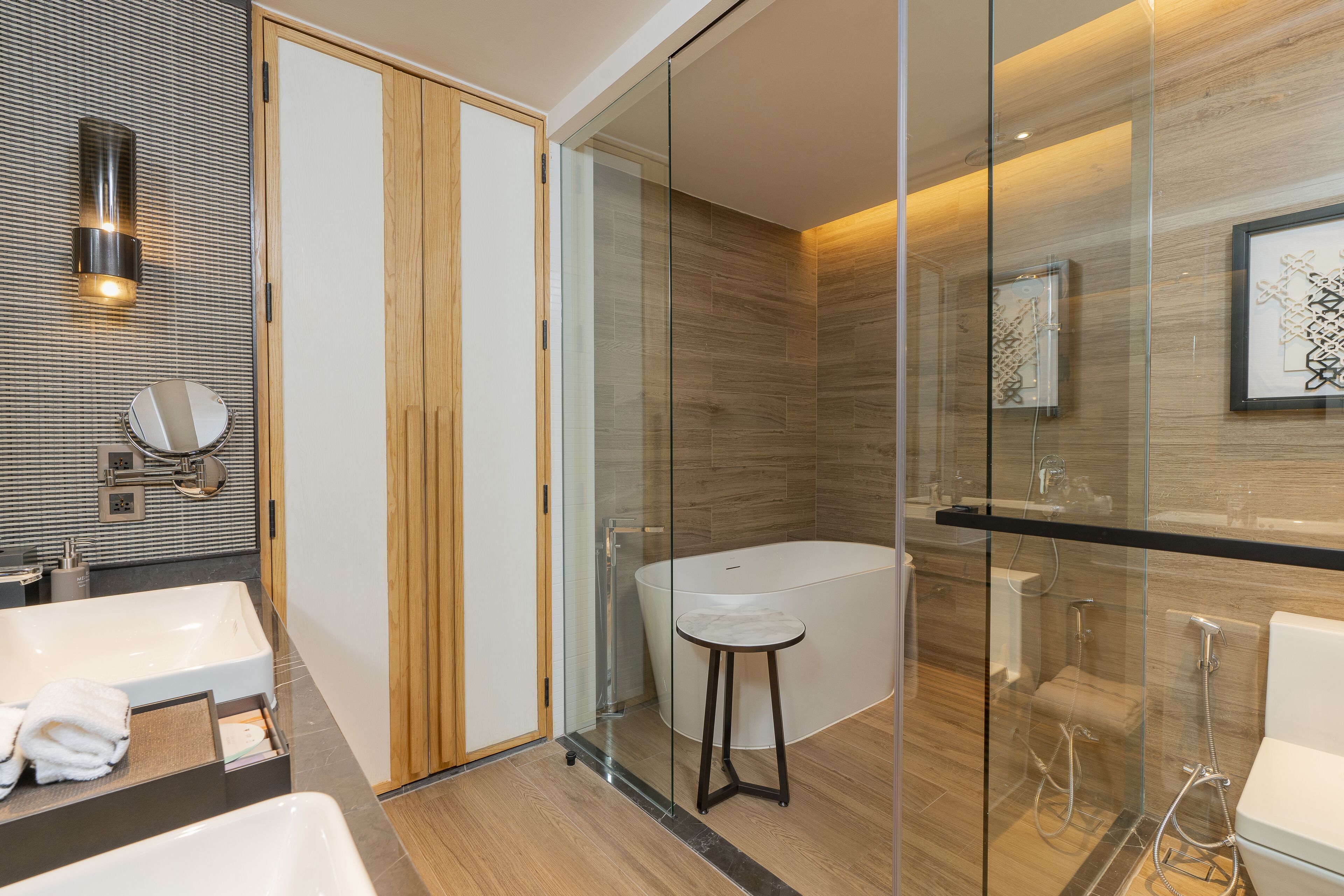 A modern bathroom with a glass-enclosed shower, a freestanding bathtub, and a vanity with a mirror.