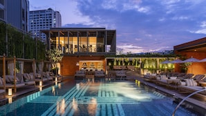 Un hôtel moderne doté d’une piscine à débordement, d’un espace détente et d’un restaurant avec une terrasse.