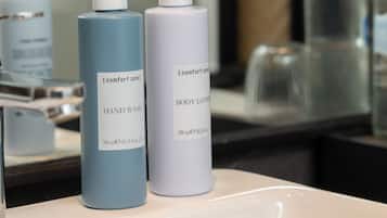 A bathroom counter with hand wash bottles and a body lotion bottle.