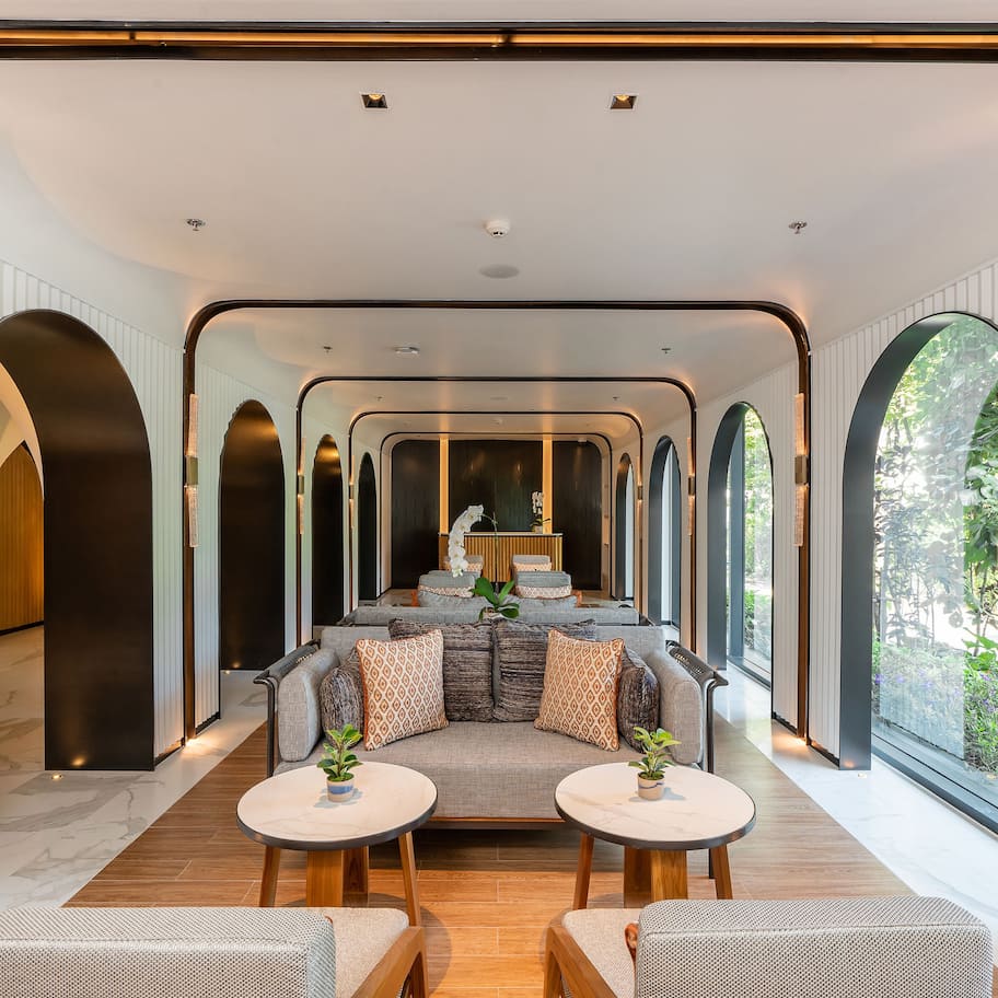 A modern interior with a central seating area, large windows, and a minimalist design.