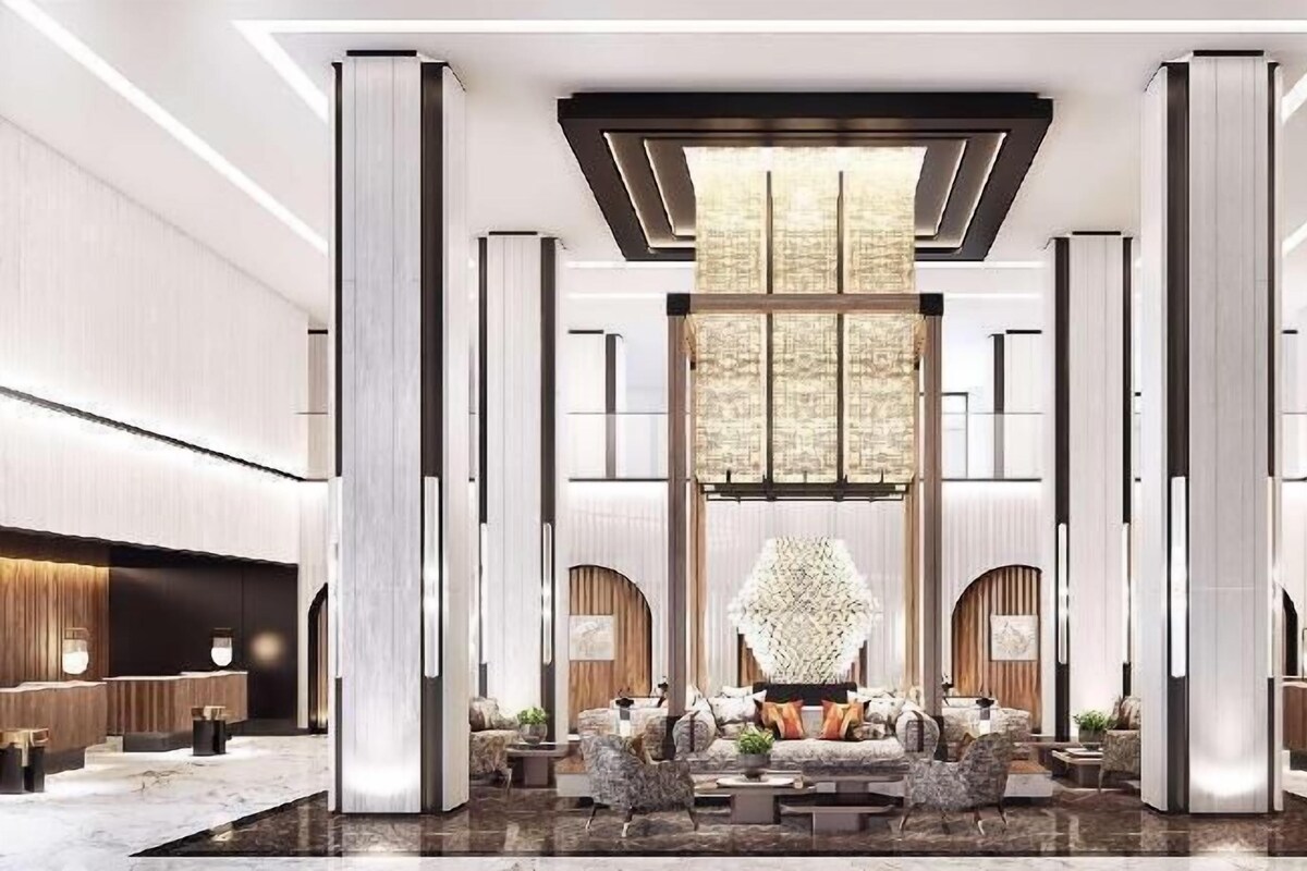 Een ruime lobby met een centraal zitgedeelte, hoge plafonds en een modern interieur.