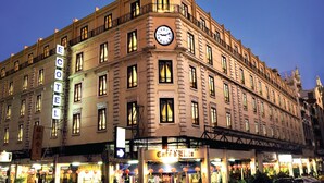 Un hôtel historique doté d’un imposant clocher, de nombreux balcons et d’un restaurant situé au rez-de-chaussée.