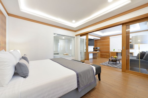 A modern hotel room with a large bed, a desk, and a seating area. - The Beverly Hotel Pattaya (Pattaya)