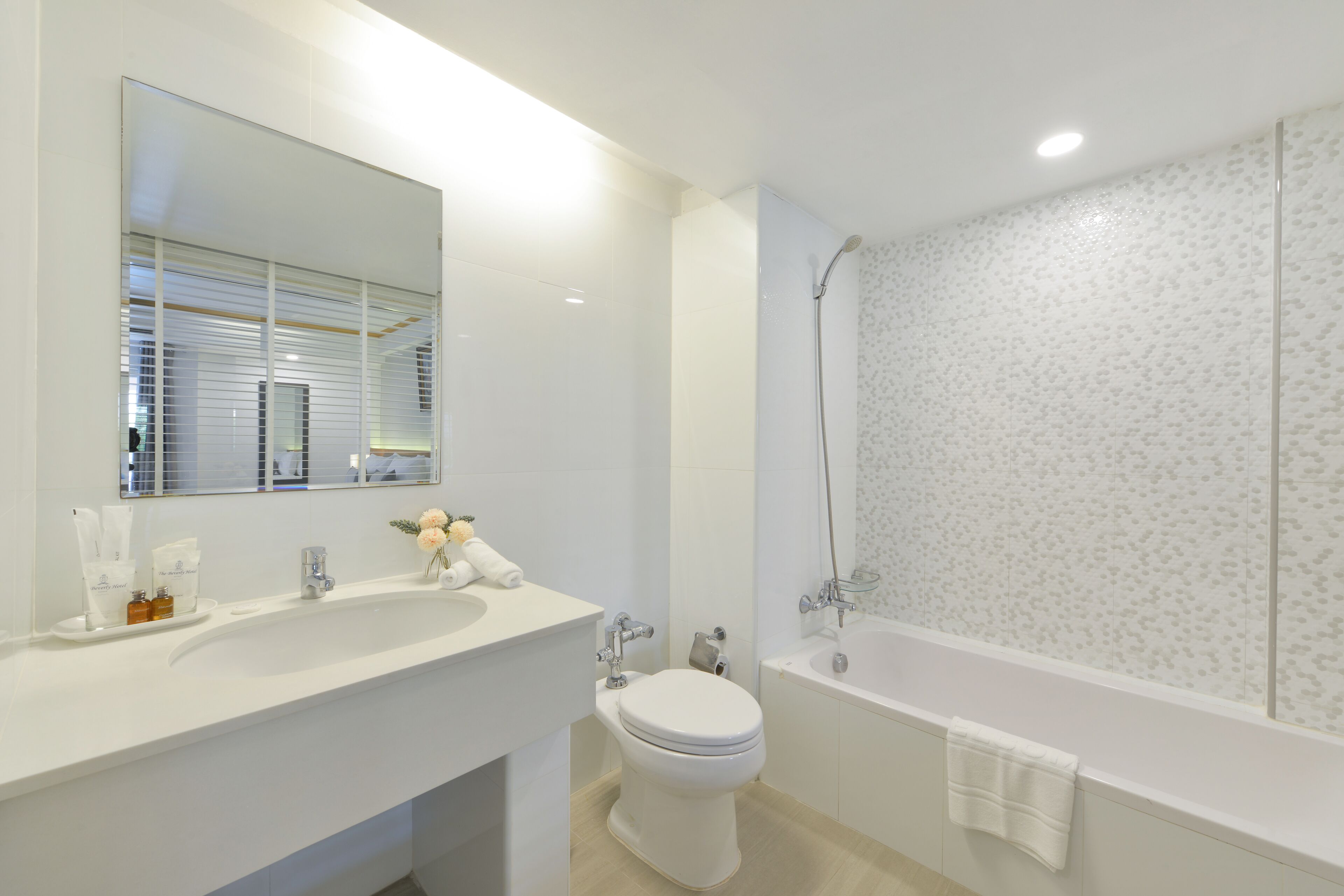 A modern bathroom with a large white sink, a toilet, and a bathtub.