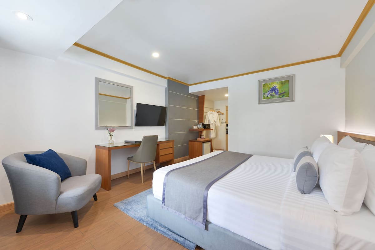 A modern bedroom with a bed, a desk, a chair, and a mirror.