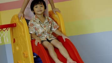 Kids can play and climb on the colorful play structure and hoop.